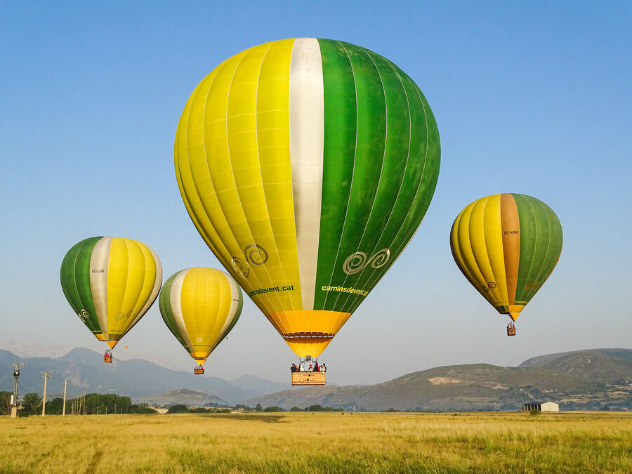 Cuatro globos de Camins de Vent volando sobre campos